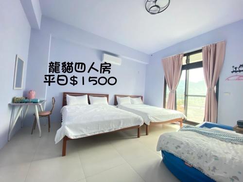 1 dormitorio con 3 camas, mesa y ventana en 騎馬三星二館 en Gongzhao