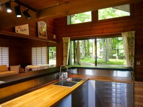 a kitchen with a sink and a large window at Forest Villa Yamanakako in Yamanakako