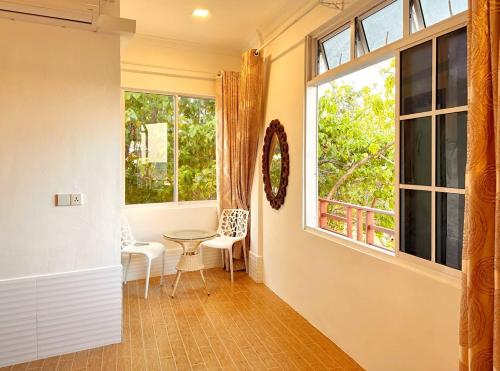 a hallway with a window and a table and chairs at Aqua Sunset in Gulhi