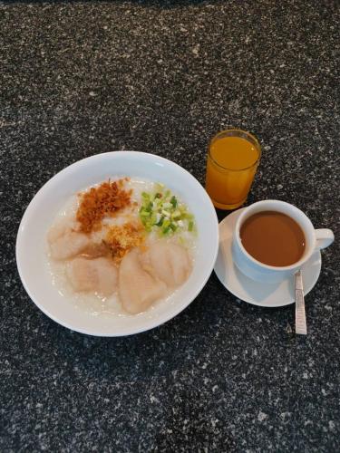 a plate of food and a cup of coffee on a table at Leenova Hotel in Bangkok