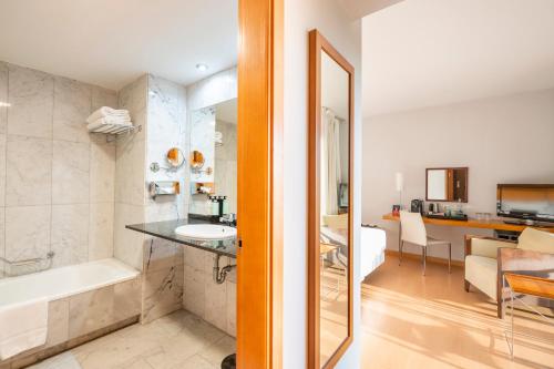 a bathroom with a tub and a sink in a room at Hesperia Barcelona Del Mar in Barcelona
