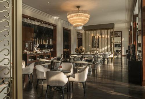 a restaurant with chairs and tables and a chandelier at Four Seasons Hotel Tianjin in Tianjin