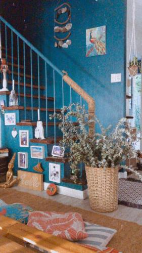 una habitación con una escalera y un jarrón de flores en Boho Inspired Home Near Rockwell, en Manila