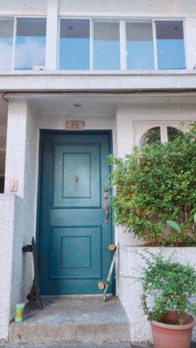 una puerta azul de una casa con una planta en Boho Inspired Home Near Rockwell, en Manila