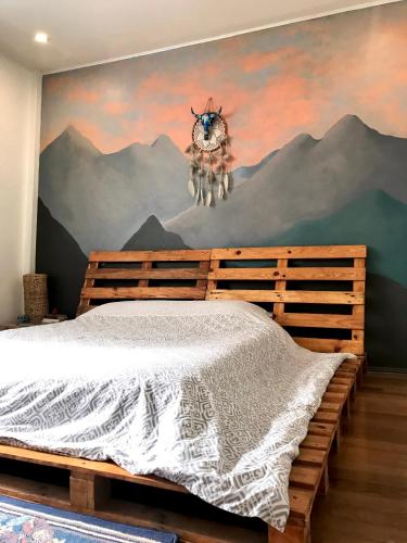 1 dormitorio con 1 cama con una pintura en la pared en Boho Inspired Home Near Rockwell, en Manila