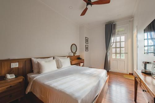 a bedroom with a bed and a ceiling fan at Le Soleil Boutique Hotel in Da Lat
