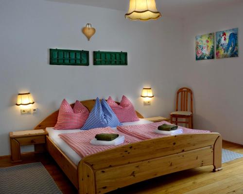 1 dormitorio con 1 cama con almohadas rosas y azules en Oberachenhof, en Ellmau