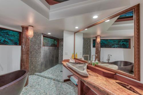 a bathroom with two sinks and a large mirror at The Kulani Maui in Lahaina
