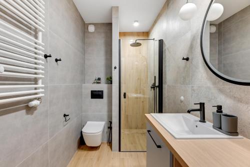 ein Bad mit einem WC, einem Waschbecken und einer Dusche in der Unterkunft Downtown Apartments City Center Aura 40 Apartments & Parking in Danzig