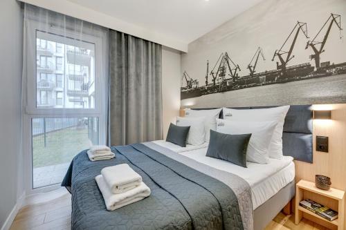 a bedroom with a large bed with towels on it at Downtown Apartments City Center Aura 40 Apartments & Parking in Gdańsk