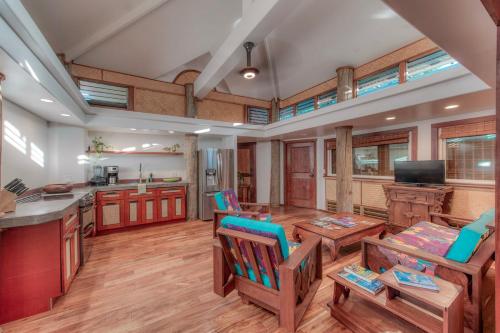 a large kitchen with wooden floors and wooden tables and chairs at The Kulani Maui in Lahaina