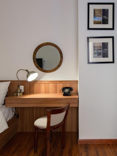 a desk in a bedroom with a mirror and a chair at Le Soleil Boutique Hotel in Da Lat