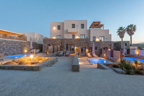 a resort with two swimming pools and a building at Paros Comfy Suites in Naousa