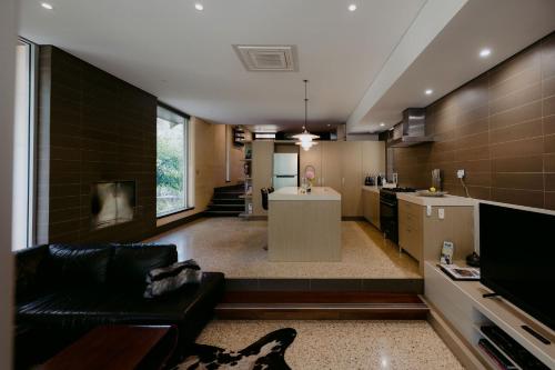 a living room with a couch and a kitchen at Losari Retreat in Margaret River Town