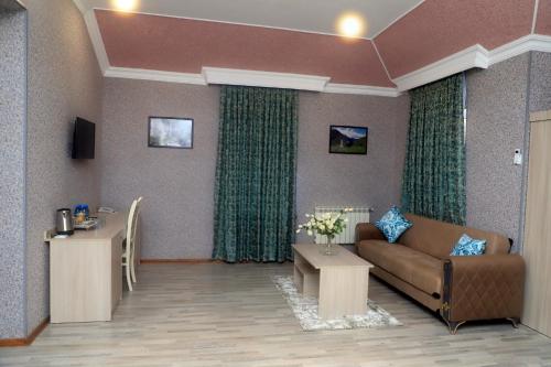 a living room with a couch and a table at RamRamay in Qax