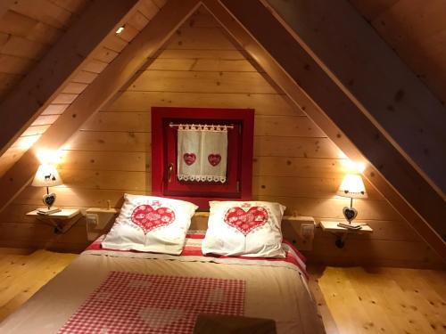 um quarto com uma cama com corações nas almofadas em Chalet Colline et Lou em Wintzfelden