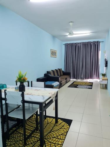 een woonkamer met een tafel en een bank bij HOMESTAY ALFARUQI GAMBANG (5) in Kampong Pohoi