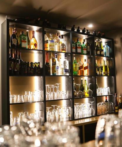 a bar with lots of alcohol bottles and glasses at Hotel Romeo in Korçë
