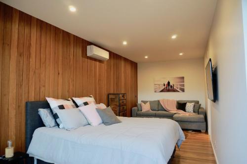 a bedroom with a large white bed and a couch at Stella on Stevens in Queenscliff