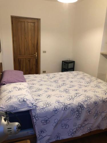 1 dormitorio con 1 cama con edredón azul y blanco en La maison de Linanna, en Aymavilles