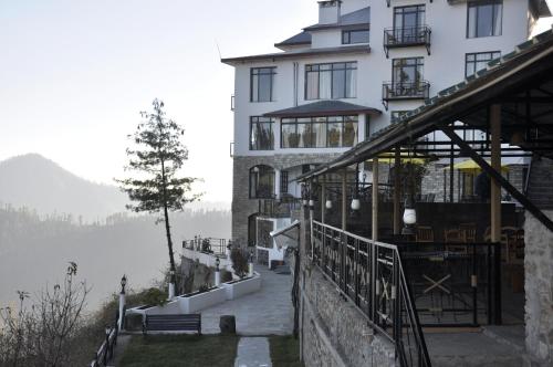 a large white building with a view of a lake at Tethys Himalaya Narkanda in Nārkanda
