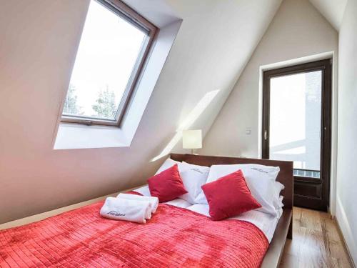 ザコパネにあるVisitZakopane - Mountain Apartmentのベッドルーム1室(赤と白の枕が備わるベッド1台付)