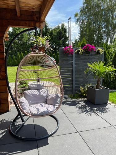 a rattan chair sitting on a patio at Bajkowe Domki in Kudowa-Zdrój