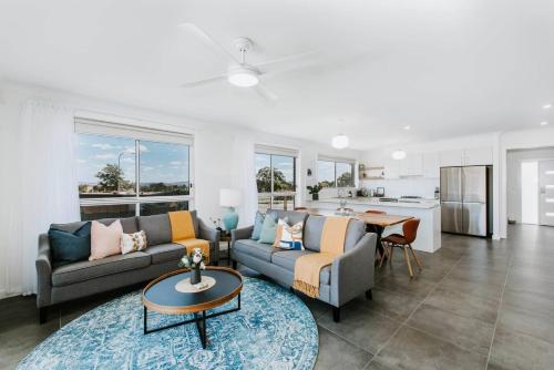 a living room with two couches and a kitchen at Helvetia - Modern Comfort meets Country Convenience in Mudgee