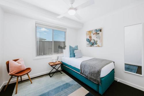 une chambre avec un lit, une chaise et une fenêtre dans l'établissement Helvetia - Modern Comfort meets Country Convenience, à Mudgee