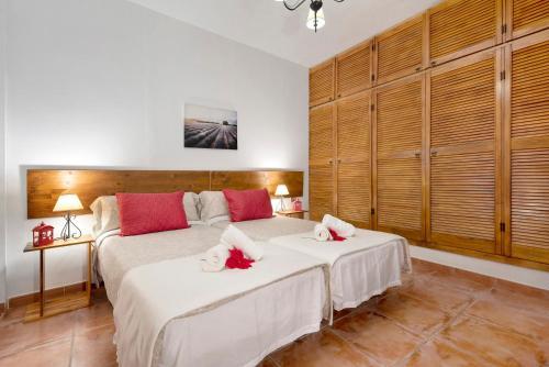 een slaapkamer met twee bedden met rode kussens erop bij Casa Teresa in La Guancha