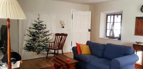 a living room with a blue couch and a christmas tree at The OldMillhouse in Mojstrana