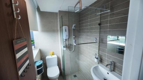 a bathroom with a shower and a toilet and a sink at Comfy Studio Kuching in Kuching