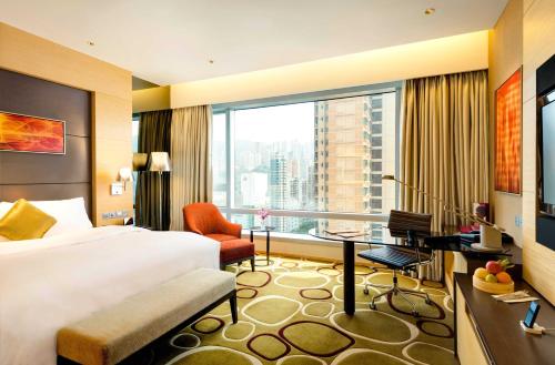 香港にあるクラウン プラザ 香港 コーズウェイ ベイのベッド、デスク、窓が備わるホテルルームです。