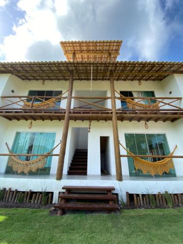 una casa con dos hamacas delante en Taipu de Fora - Villa Ohana Flats en Taipu