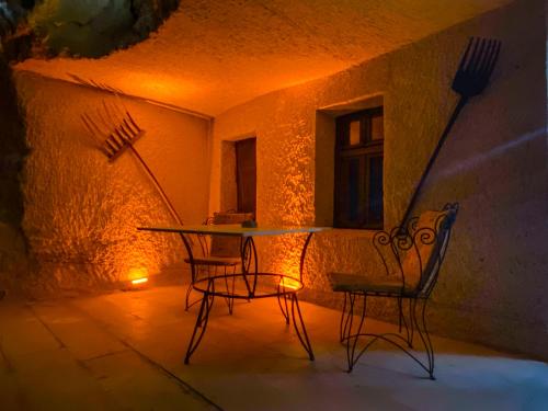 een tafel en twee stoelen op een patio in de nacht bij Milagre Cave Hotel in Goreme