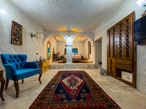 uma sala de estar com uma cadeira azul e um tapete em Milagre Cave Hotel em Goreme