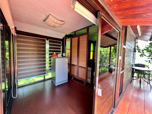 an outside view of a house with a refrigerator on a porch at MrT Riverside Sampran มิสเตอร์ที โฮมสเตย์-ช้องนาง in Sam Phran