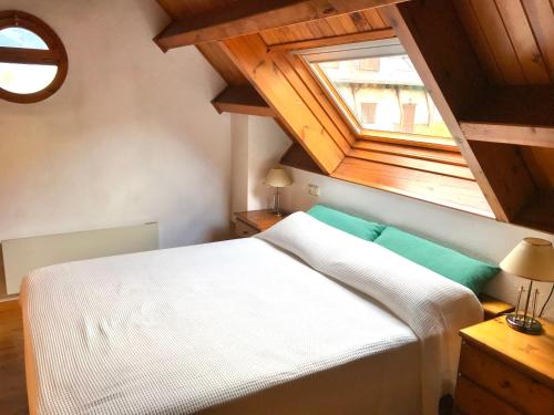 Un dormitorio con una cama blanca y una ventana. en Allotjament SV, en Pla de l'Ermita
