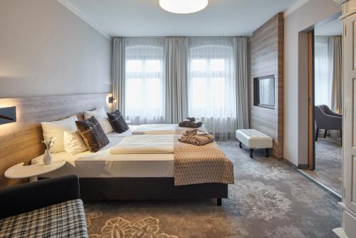 ein Hotelzimmer mit einem großen Bett und einem Schreibtisch in der Unterkunft Hotel Via Regia - VIAs-Hotels in Görlitz