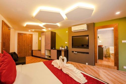 a hotel room with a bed and a television at Kuruva Island Resort And Spa - By KABINI BREEZE in Mananthavady