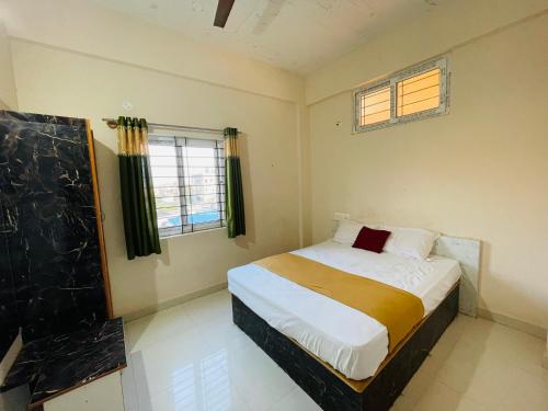 a bedroom with a bed and a window in it at STAYMAKER CP Residency in Mysore