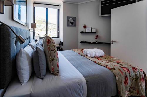 a bedroom with a large bed with pillows at Flamingo Sea Point Sea View Luxury Best Position 1 Bedroom Apartment Queen Size Bed & Inverter For TV in Cape Town