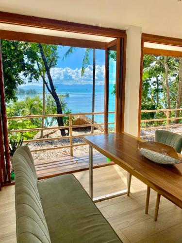 a dining room with a table and a view of the ocean at Kalulushi Bungalows in Haad Pleayleam