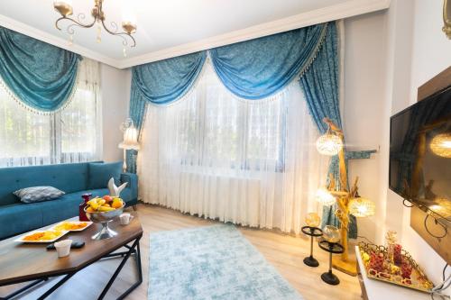 a living room with blue curtains and a blue couch at Fera Life Suit Apart in Trabzon