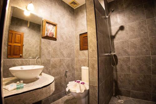W łazience znajduje się prysznic, umywalka i toaleta. w obiekcie Rico's Patong Hotel w Patong Beach