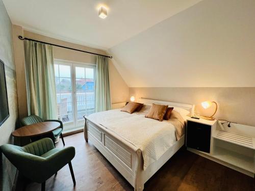 sypialnia z łóżkiem, krzesłem i oknem w obiekcie Haus Nordlicht w mieście Ahrenshoop