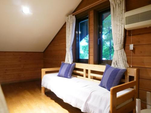 1 dormitorio con cama y ventana en Forest Villa Yamanakako en Yamanakako