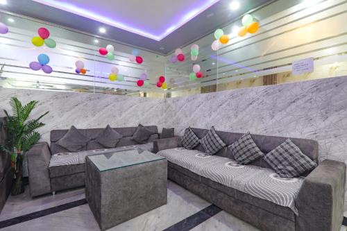 ein Wohnzimmer mit einem Sofa und einer Wand mit Ballons in der Unterkunft FabExpress SS Grand in Banthra Sikandarpur