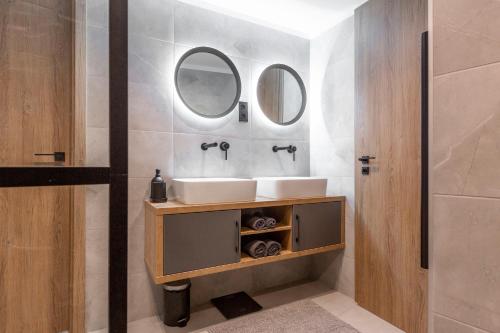 a bathroom with a sink and two mirrors at Exclusive New York Residence in the Heart of Budapest in Budapest