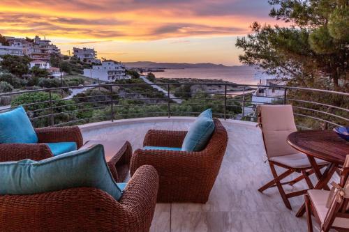 a patio with chairs and tables and a view of the ocean at BIG BLUE in Rafina